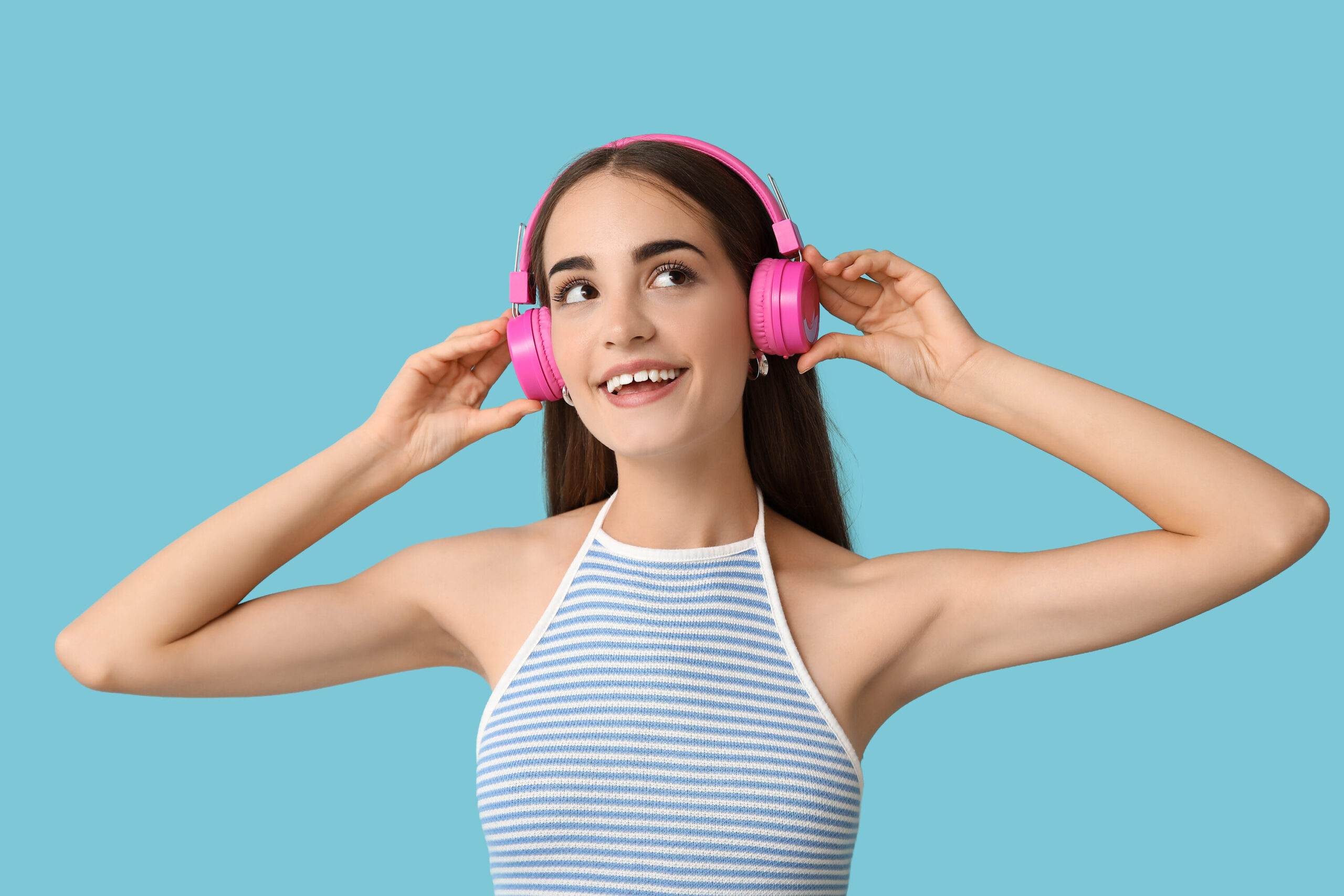 Girl smiling with a gap in her teeth, listening to music on headphones